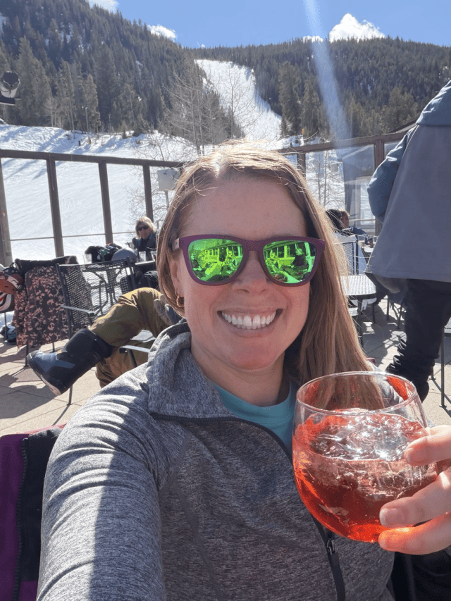 Renee Hill on a sunny ski deck with a drink, years after appendix cancer treatment